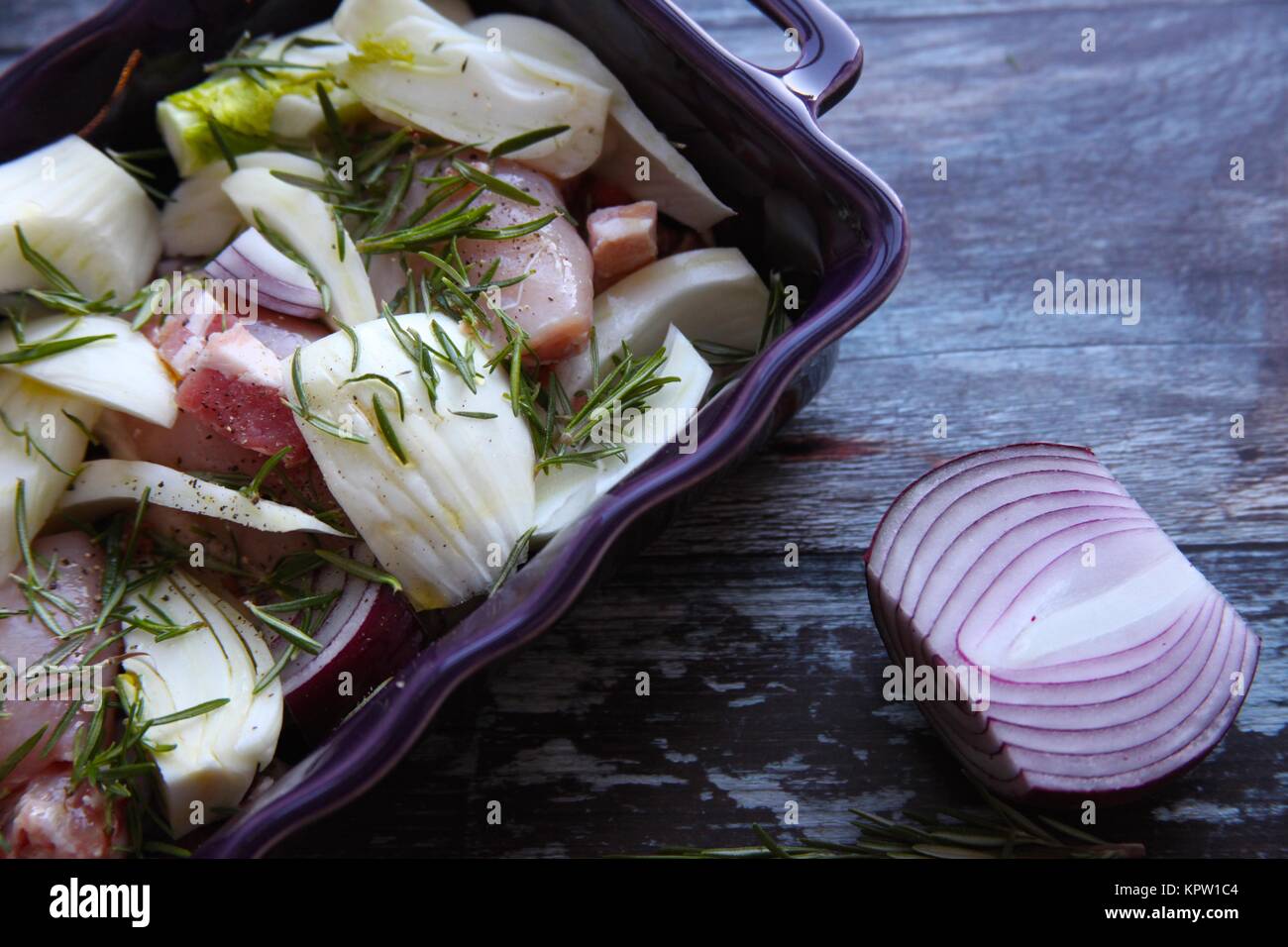 Sunday lunch preparations ,chicken with bacon, fennel and rosemary Stock Photo