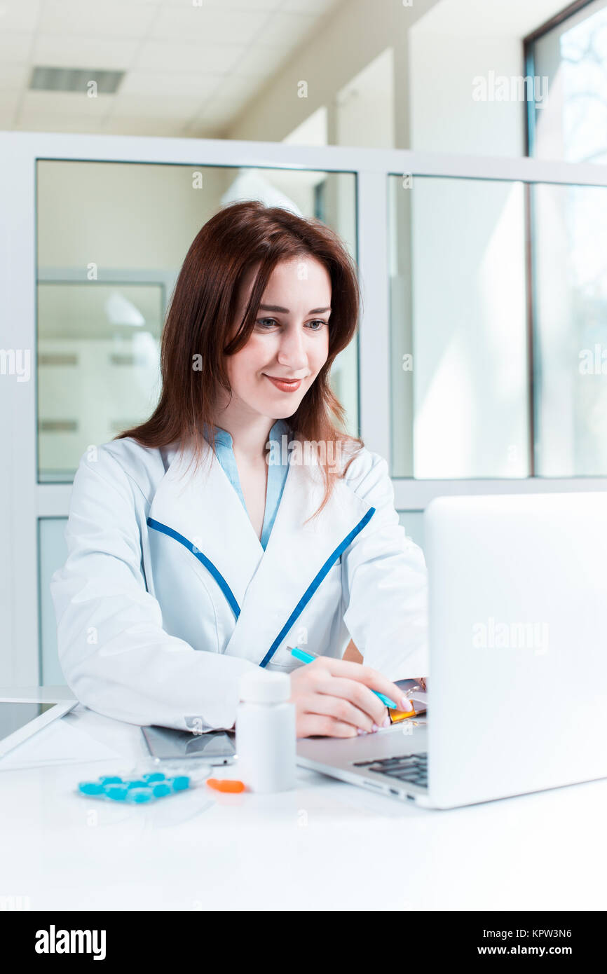 Woman doctor sitting at the table Stock Photo