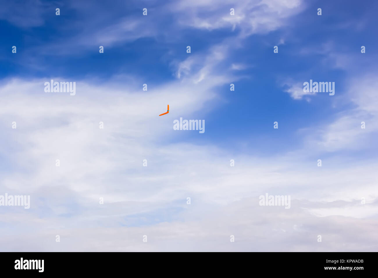 Orange boomerang flying in the sky Stock Photo