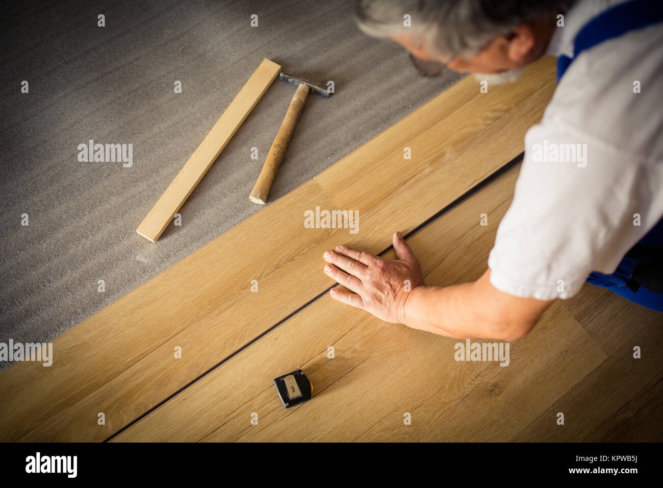 Close up of male hands lying parquet floor board/laminate flooring Stock Photo