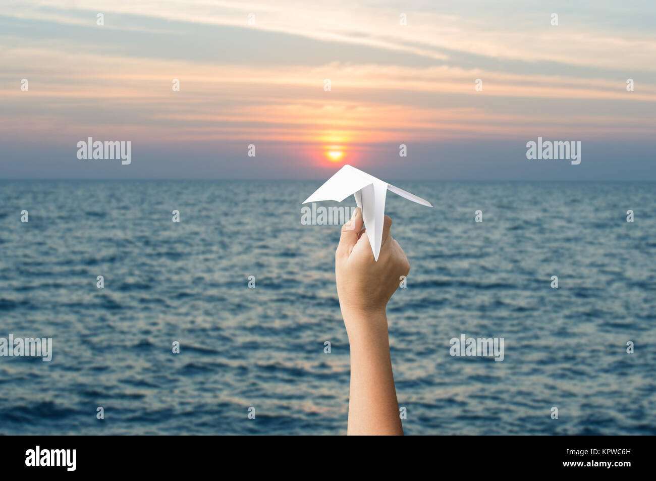 plane paper in children hands and sunset, forward to the target concept. Stock Photo