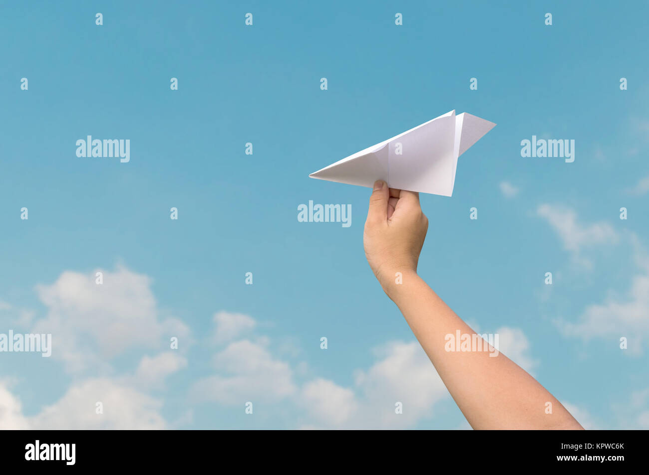 plane paper in children hand and blue sky Stock Photo