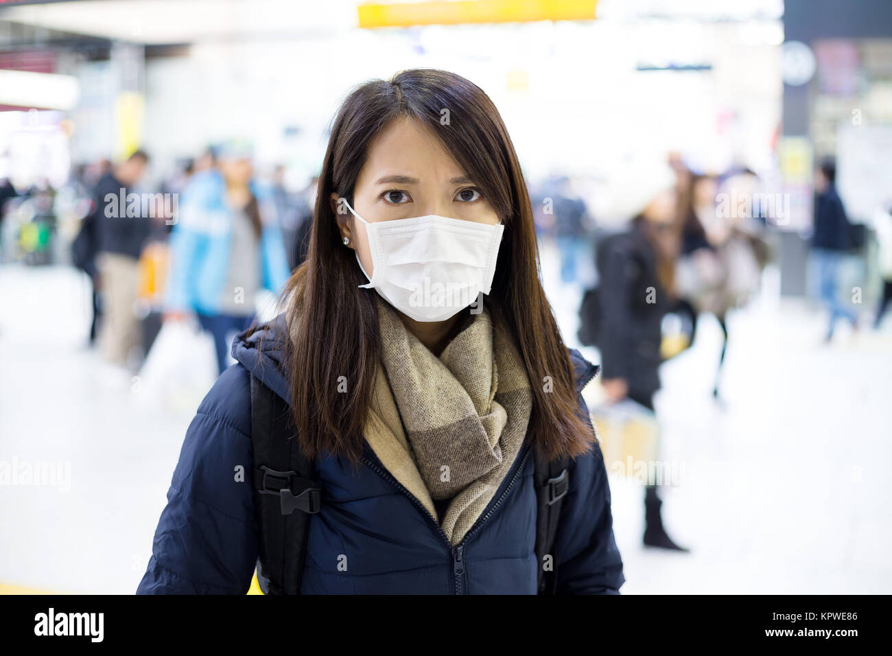 Woman wearing face mask in train station Stock Photo
