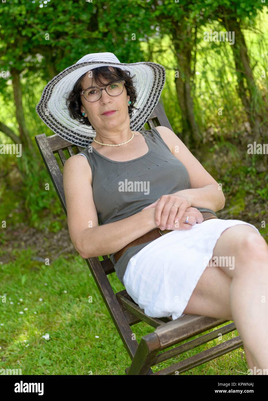 a beautiful woman relaxing in the garden with summer hat Stock Photo ...