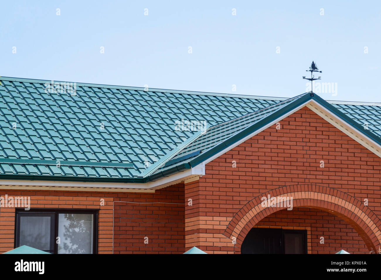 Facade of a brick building with a green roof made of metal Stock Photo ...
