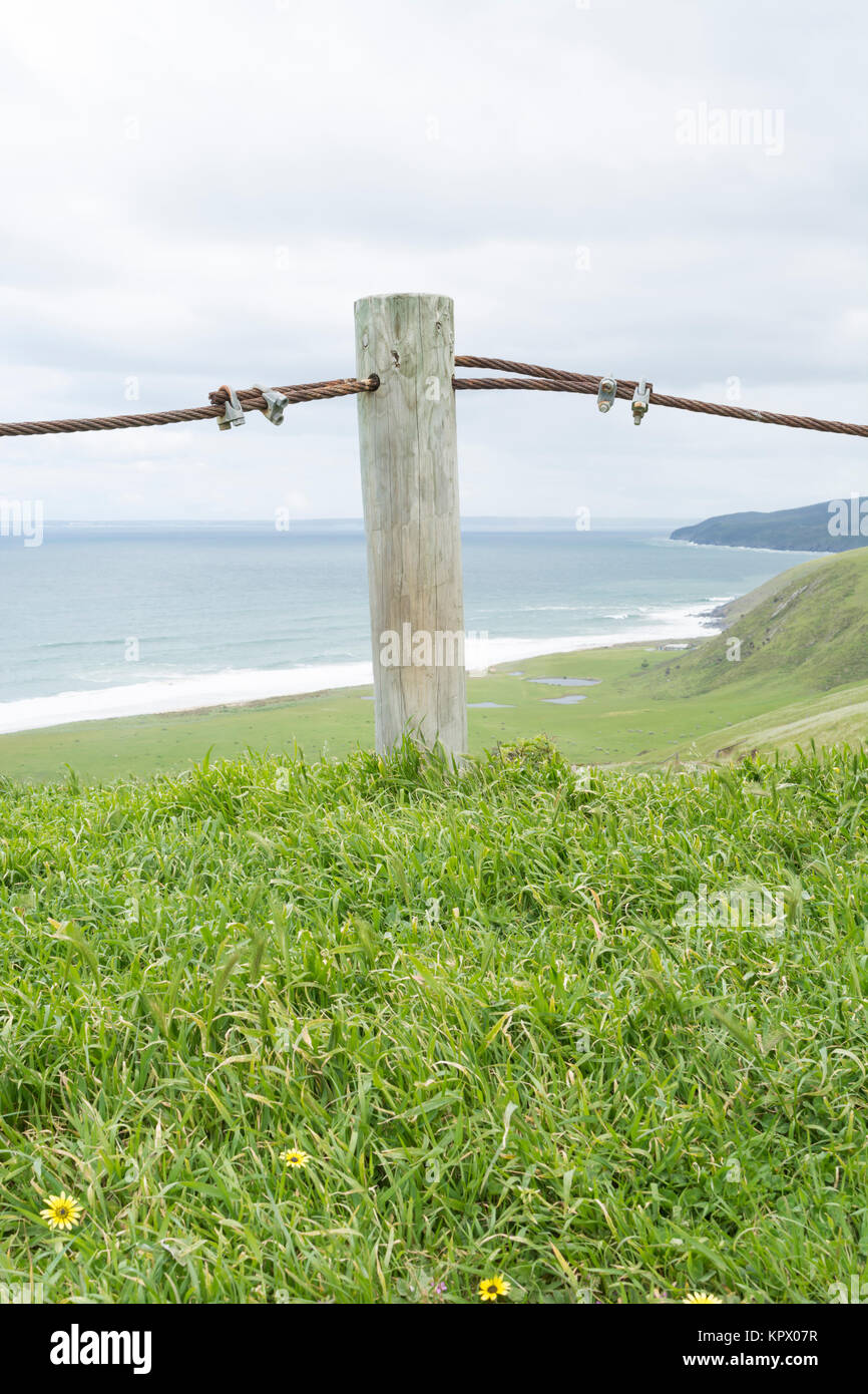 Coastal view featuring a single wooden fence post with metal rope divide at Tunkalilla Beach, South Australia, part of the Fleurieu Peninsula. Portfol Stock Photo