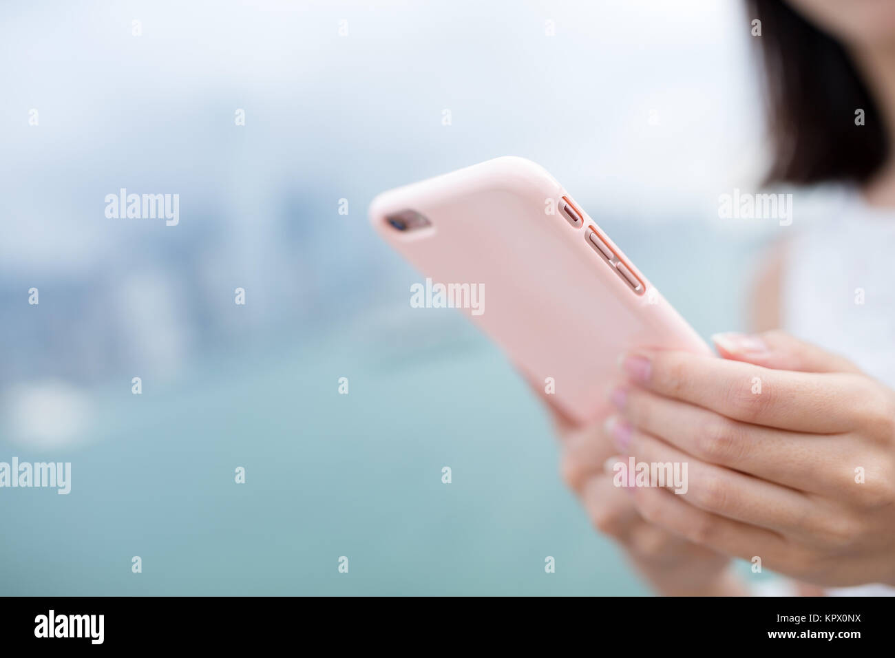 Woman using mobile phone with the background of Hong Kong skyline Stock ...