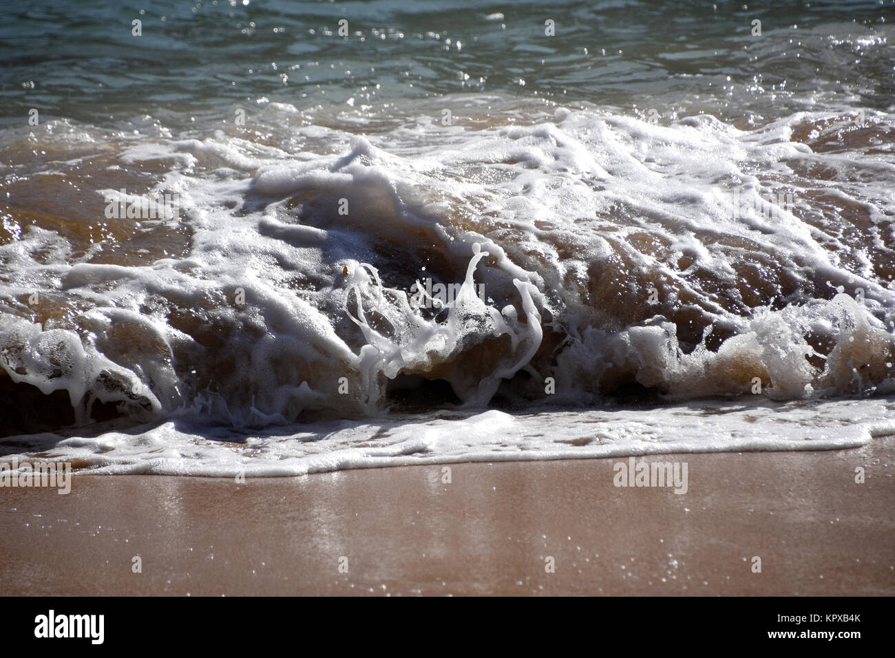 Waves and foam on the beach Stock Photo - Alamy
