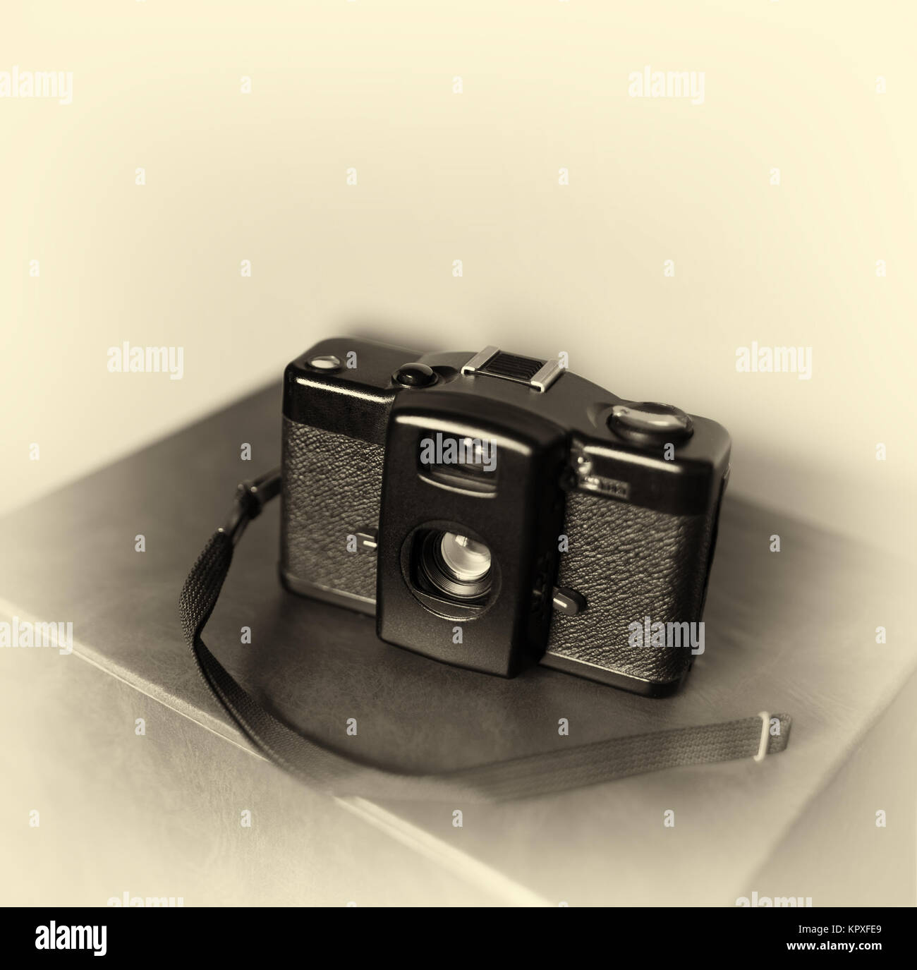 Vintage camera with strap bokeh background Stock Photo - Alamy