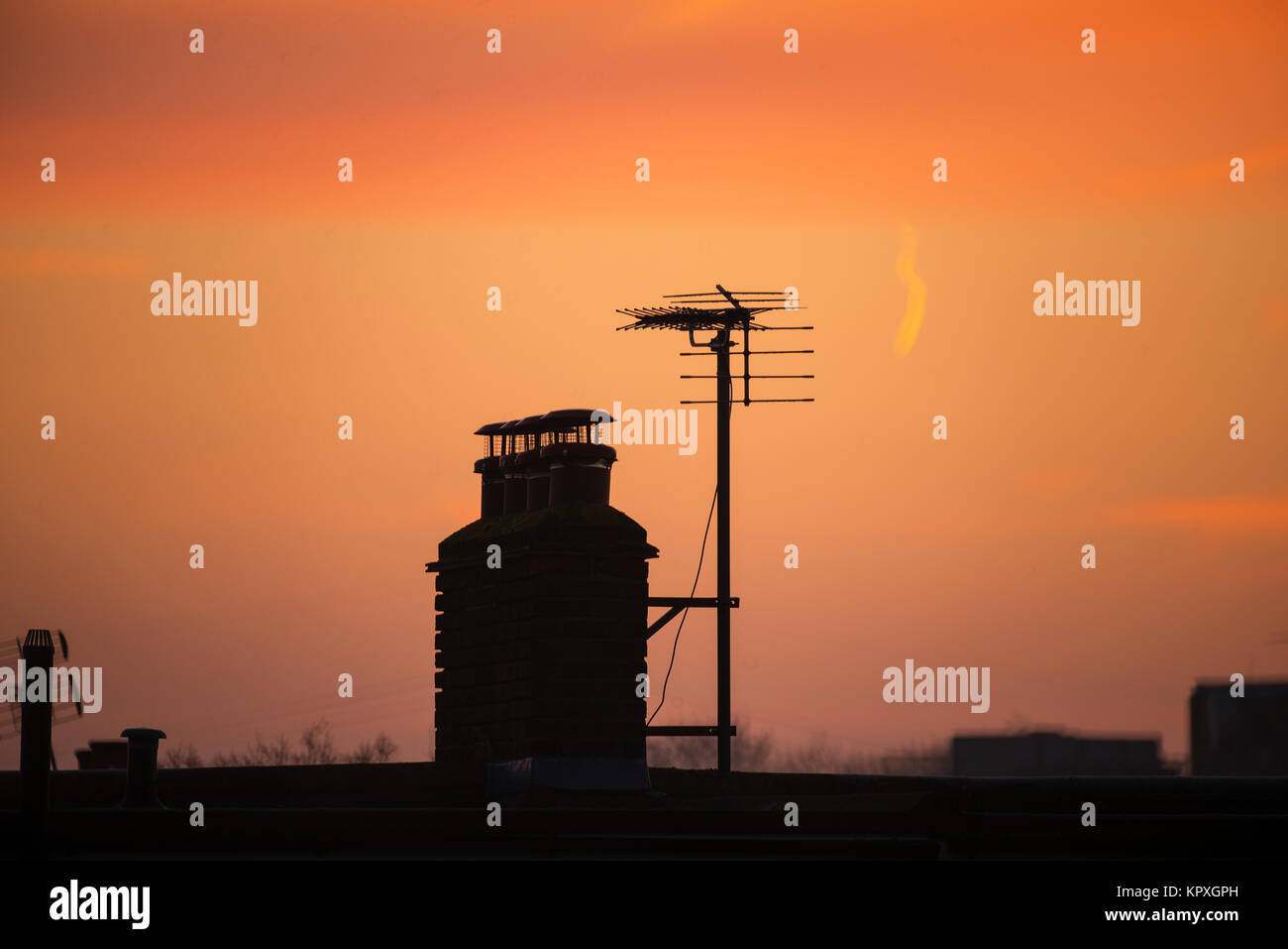 Merton, London, UK. 17 December, 2017. Dawn breaks  with orange sky over rooftops with a heavy frost and colourful skies 8 days before Christmas Eve. Credit: Malcolm Park/Alamy Live News. Stock Photo
