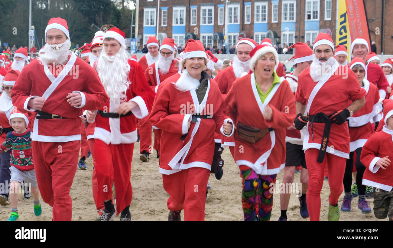 Weymouth Beach, Dorset, UK. 17 December 2017. Hundreds of Santas descended on Weymouth to chase runners dressed as Christmas Puddings along a 5k route on Weymouth Seafront. The event, which is celebrating its tenth year, raises funds for local charity the Will Mackaness Trust which supports local children take up swimming and water sports. Tom Corban/Alamy Live News Stock Photo
