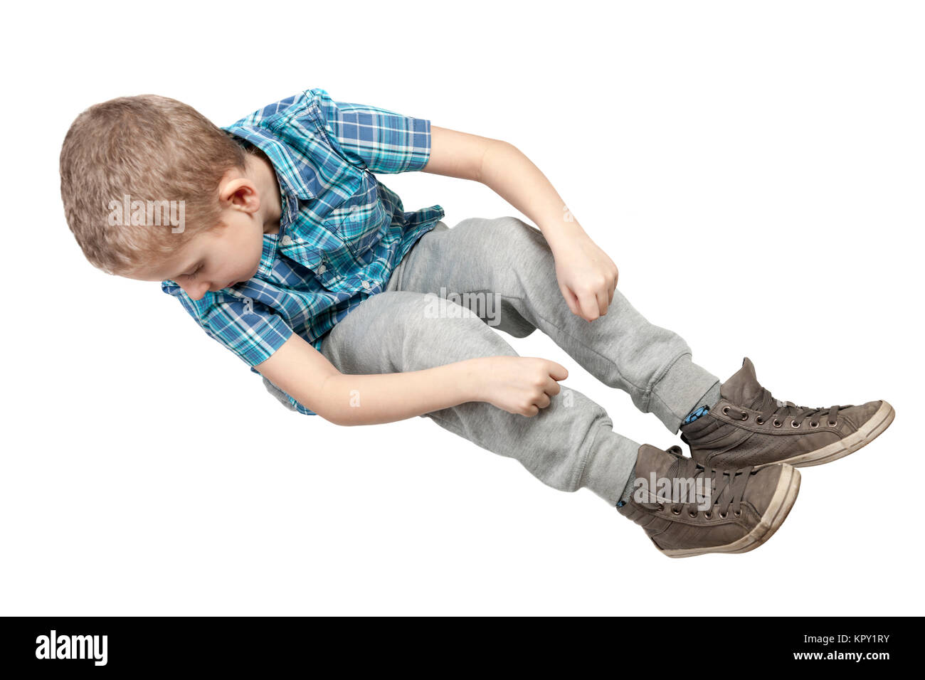 Erhöhte Ansicht auf einen neunjährigen auf Weiss freigestelten Boden Jungen nach unten blickend und ein imaginäres Seil haltend Stock Photo