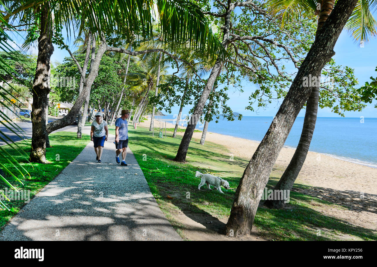 Senior couple walking their dog along the Esplanade, Trinity Beach, a popular Northern Beaches suburb of Cairns, Far North Queensland, FNQ, QLD, Austr Stock Photo