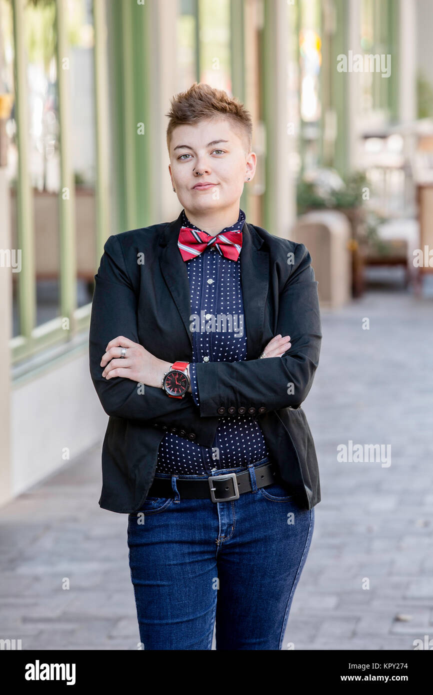 Dapper Gender Fluid Young Woman with Arms Crossed Stock Photo