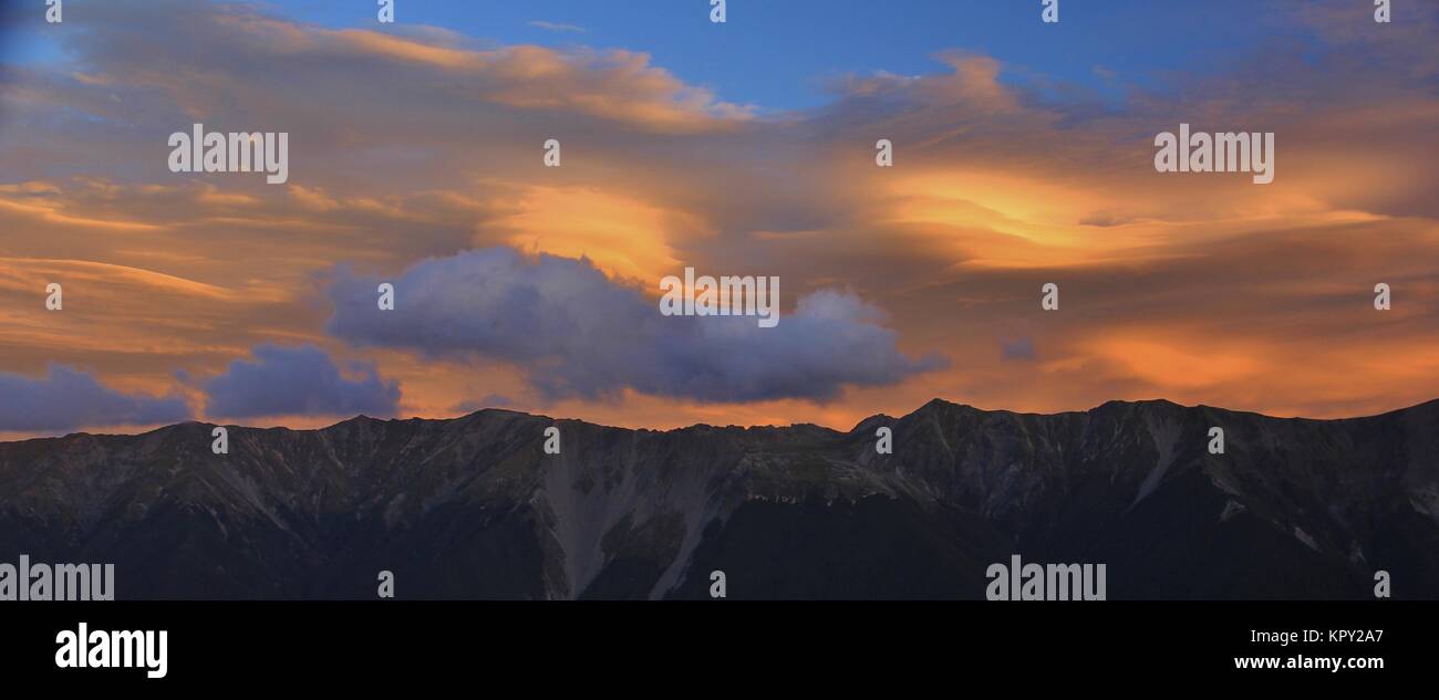 Orange clouds over a mountain range Stock Photo - Alamy