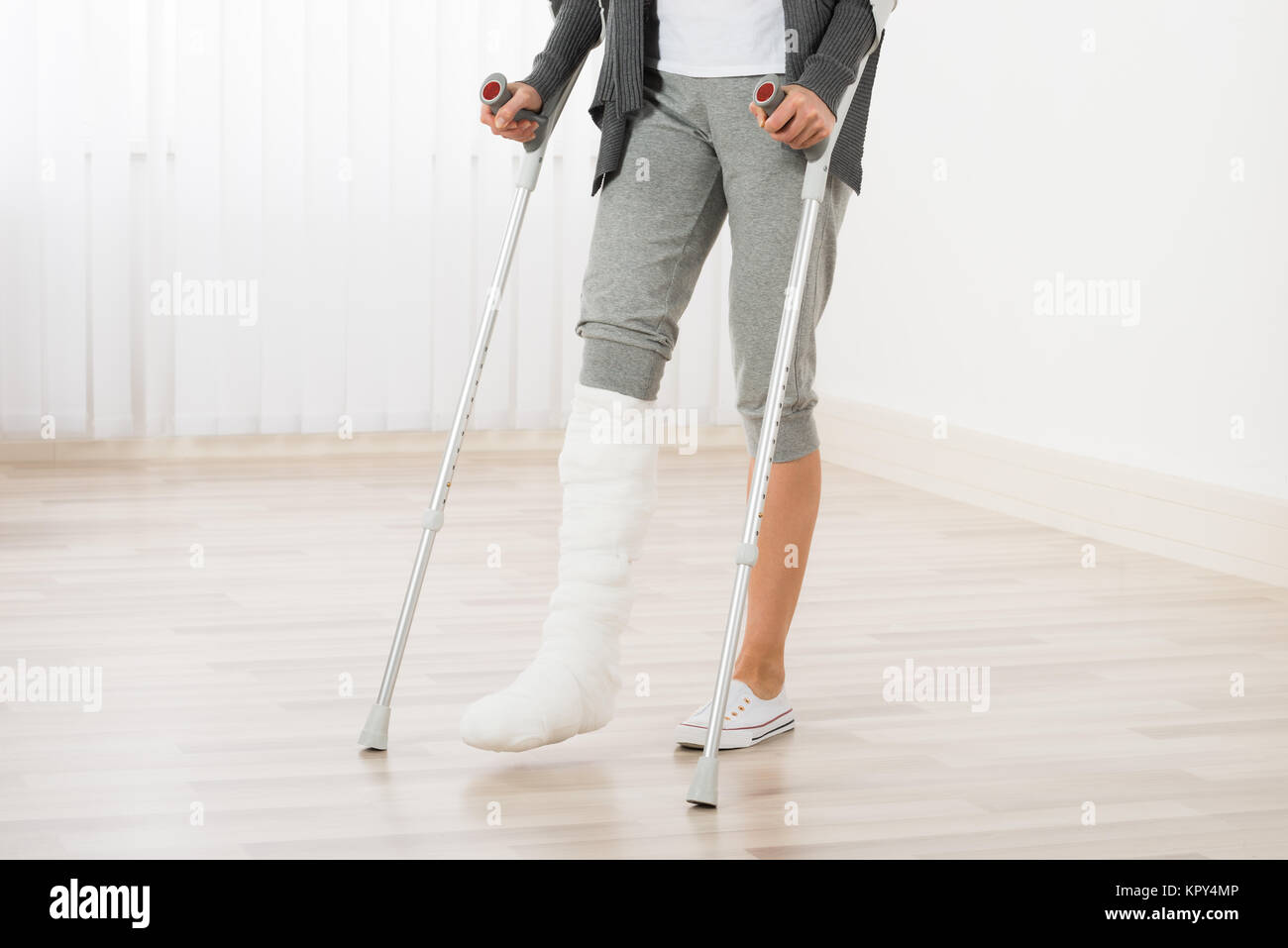 Woman Using Crutches While Walking Stock Photo - Alamy