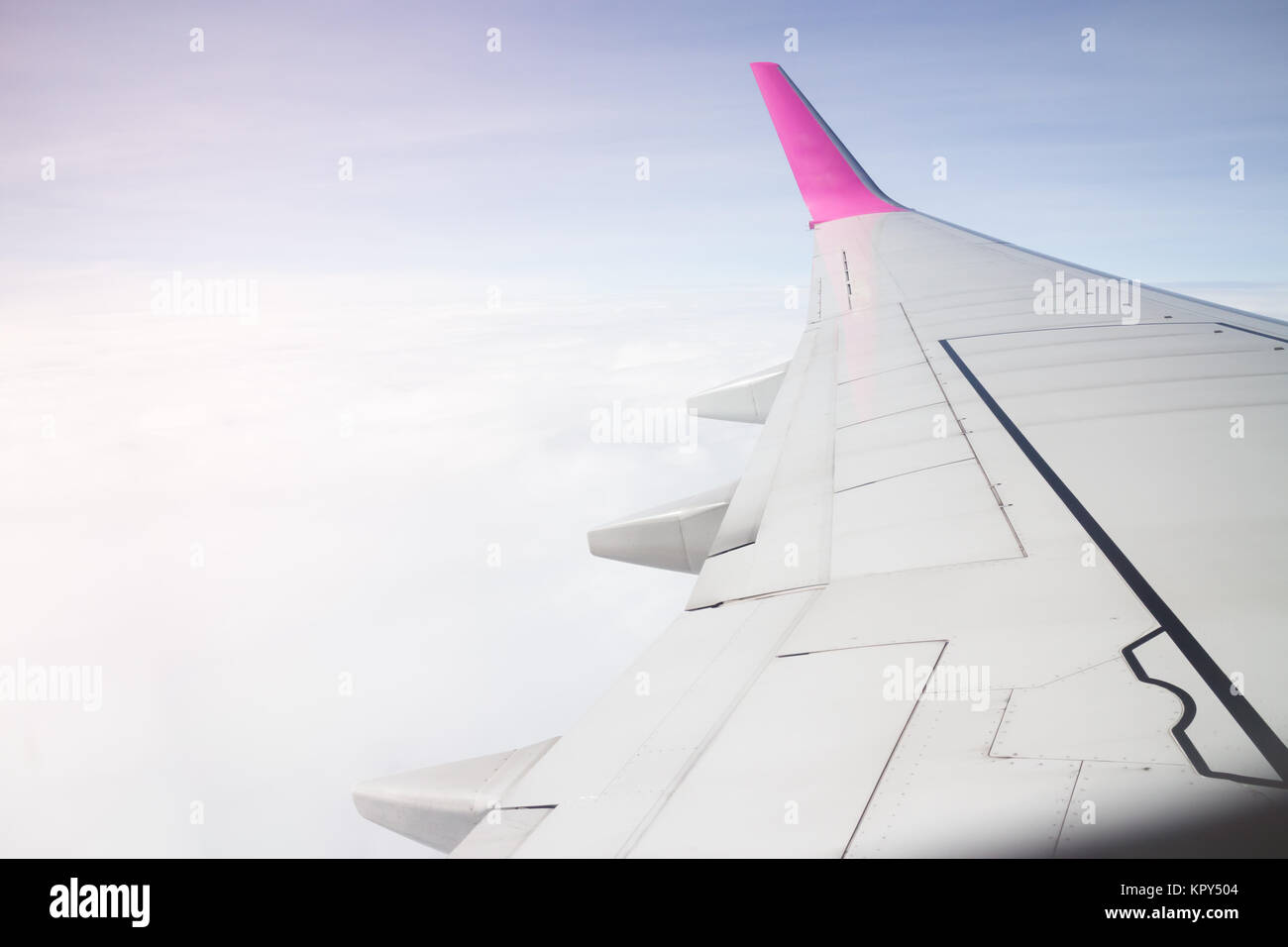Airplane wing flying above the clouds sunset Stock Photo - Alamy