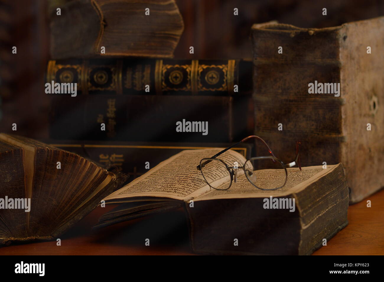 antique books with reading glasses in a dusty room Stock Photo