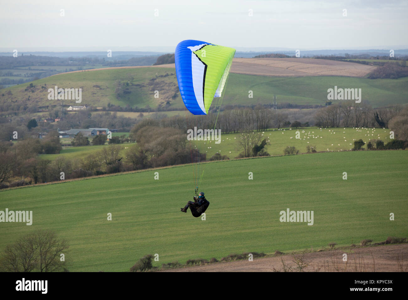 Paragliding on a cold day at Butser Hill near Petersfield Hampshire. Great location where many clubs meet to take advantage of the perfect conditions. Stock Photo