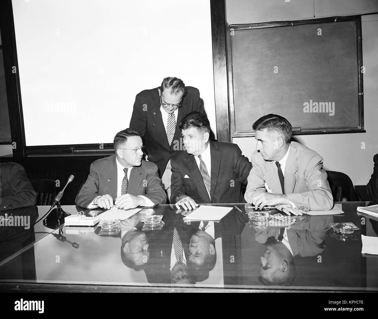 This 1956 photograph depicts four CDC officials during a bid opening meeting for the construction of new CDC facilities, 1956. Various governmental contracts are governed by established protocols, which often include a bidding process amongst interested parties. Image courtesy CDC. Stock Photo
