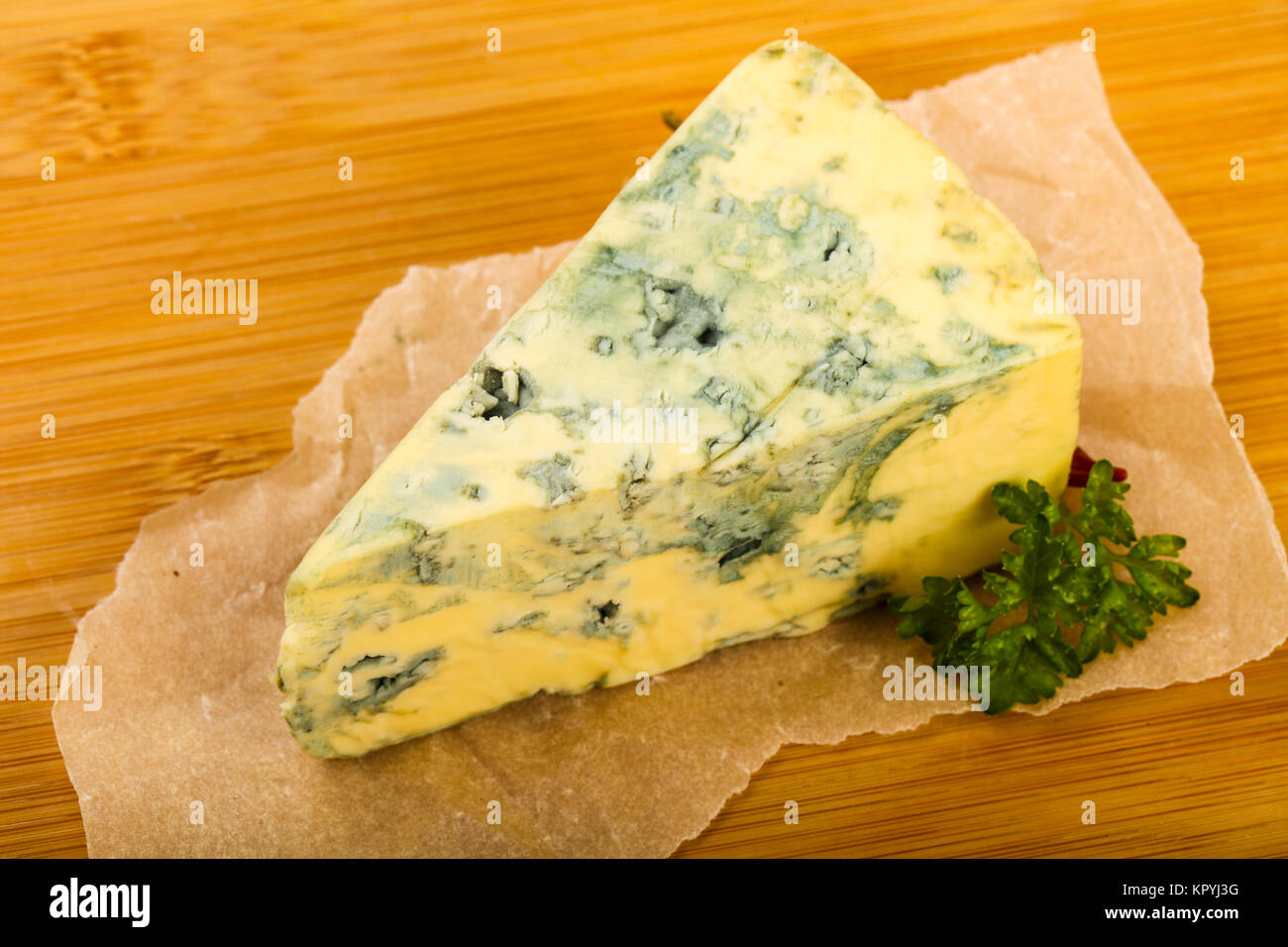 Blue cheese with parsley over wooden background Stock Photo Alamy