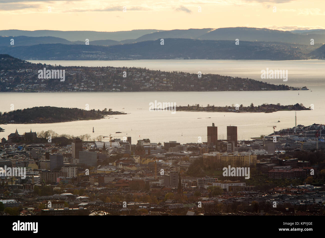 Long range elevated aerial view through centrum of Oslo with harbour and town hall (foreground), and Oslofjord islands and coastline. Stock Photo