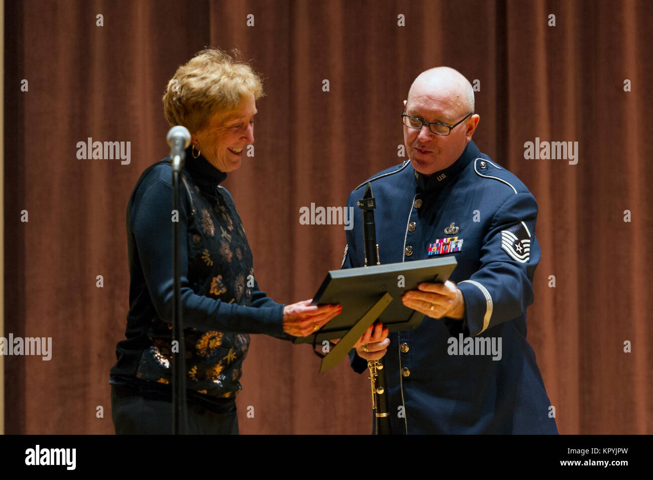 Master Sgt. Mark Craig, Air Force Band of the West NCO in charge, presents a gift to Dr. Suzanne Shipley, Midwestern State University president, to thank her for hosting the concert at the school's Akin Auditorium Dec. 13, 2017. The band travels 125,000 miles annually while on tour. (U.S. Air Force Stock Photo