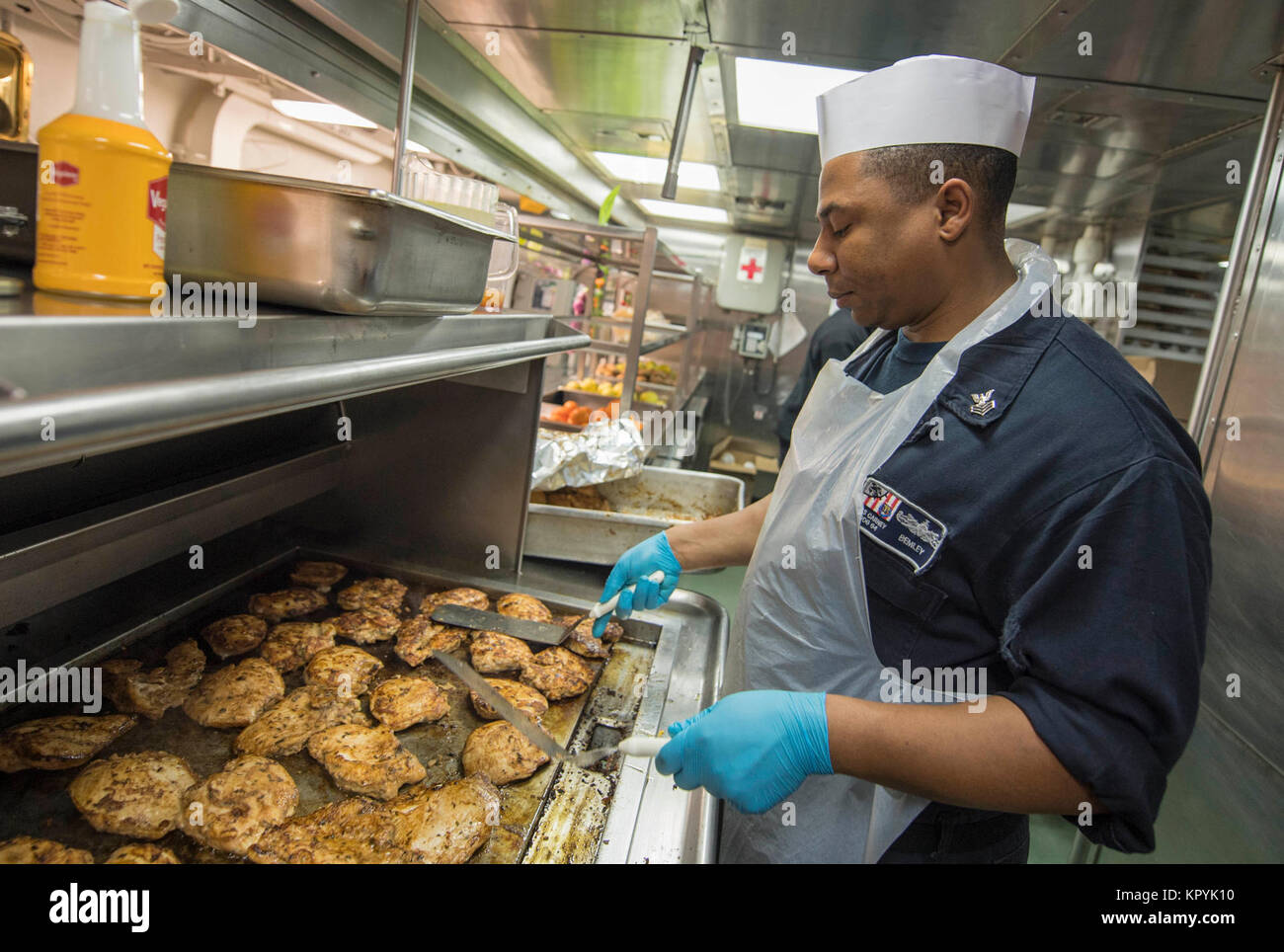 SEA (Dec. 13, 2017) - Culinary Specialist 1st Class Charles Bemley grills chicken for the ship's crew aboard the Arleigh Burke-class guided-missile destroyer USS Carney (DDG 64), Dec. 13, 2017. Carney, forward-deployed to Rota, Spain, is on its fourth patrol in the U.S. 6th Fleet area of operations in support of regional allies and partners, and U.S. national security interests in Europe. (U.S. Navy Stock Photo