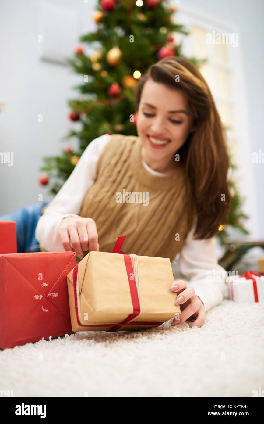 Pretty Woman Unwrapping Christmas Present Stock Photo