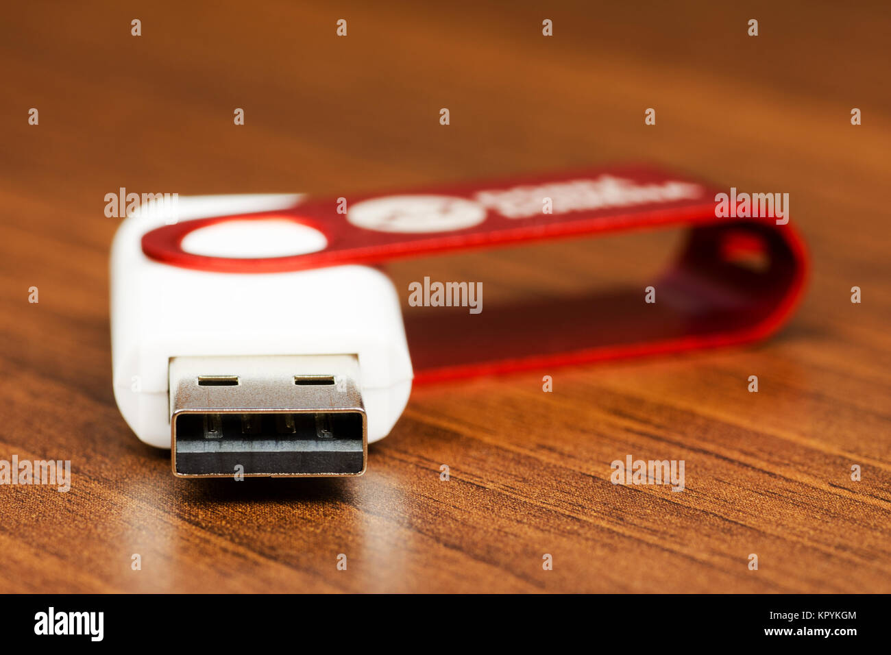 Close-up view of a white USB Flash Drive connector with red cap, on a wooden background Stock Photo