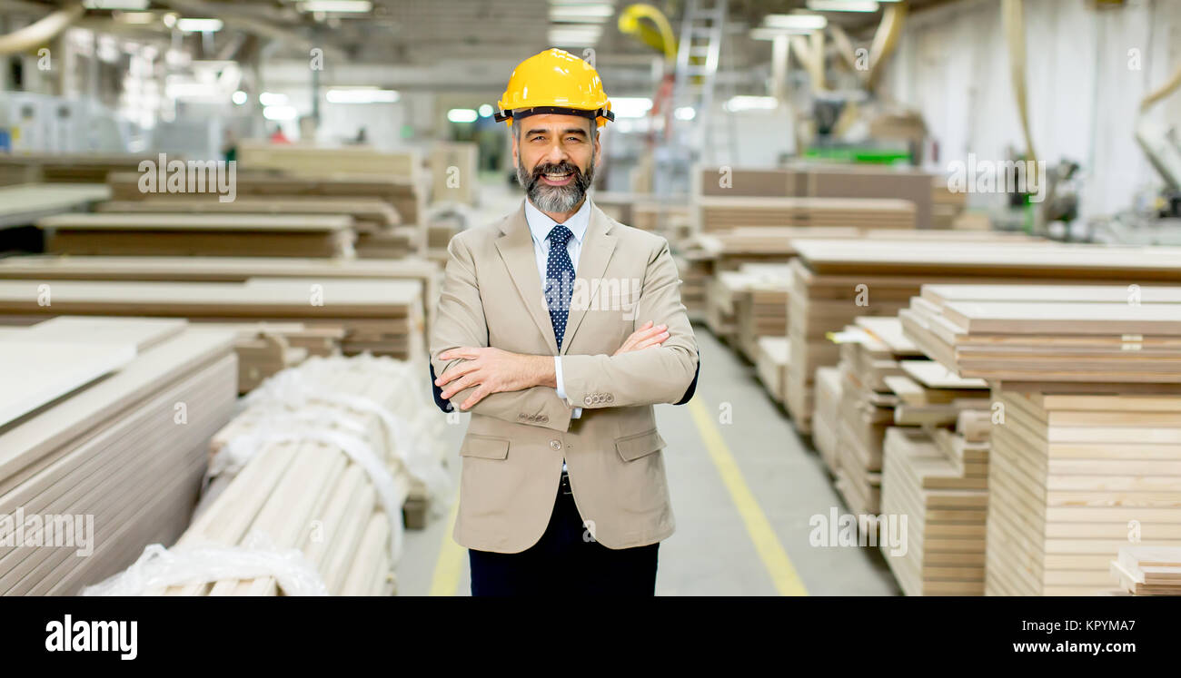 Portrait of senior handsome businessman in suit with helmet in a ...
