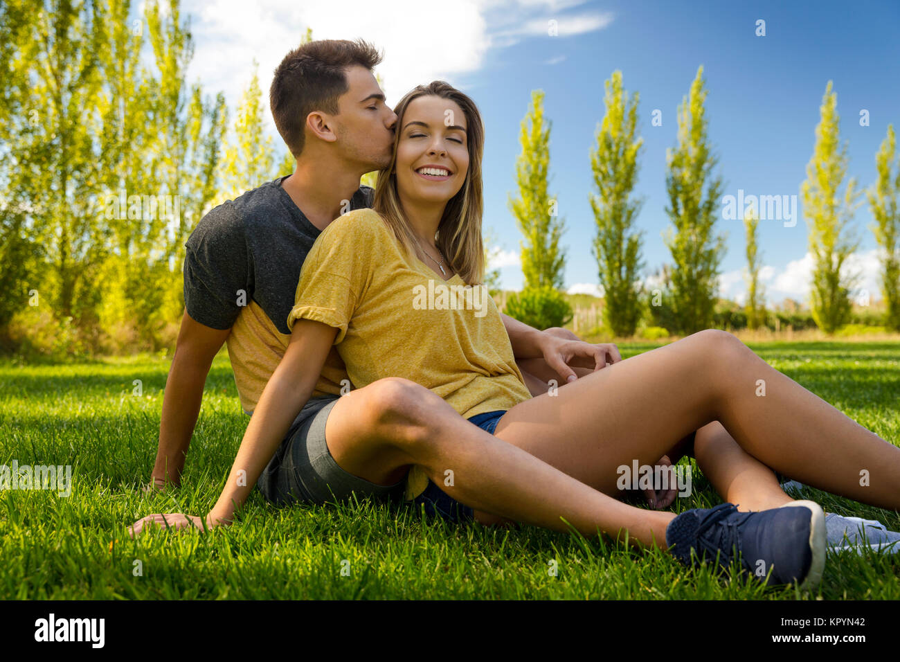 Young couple sitting on the grass and relaxing Stock Photo - Alamy