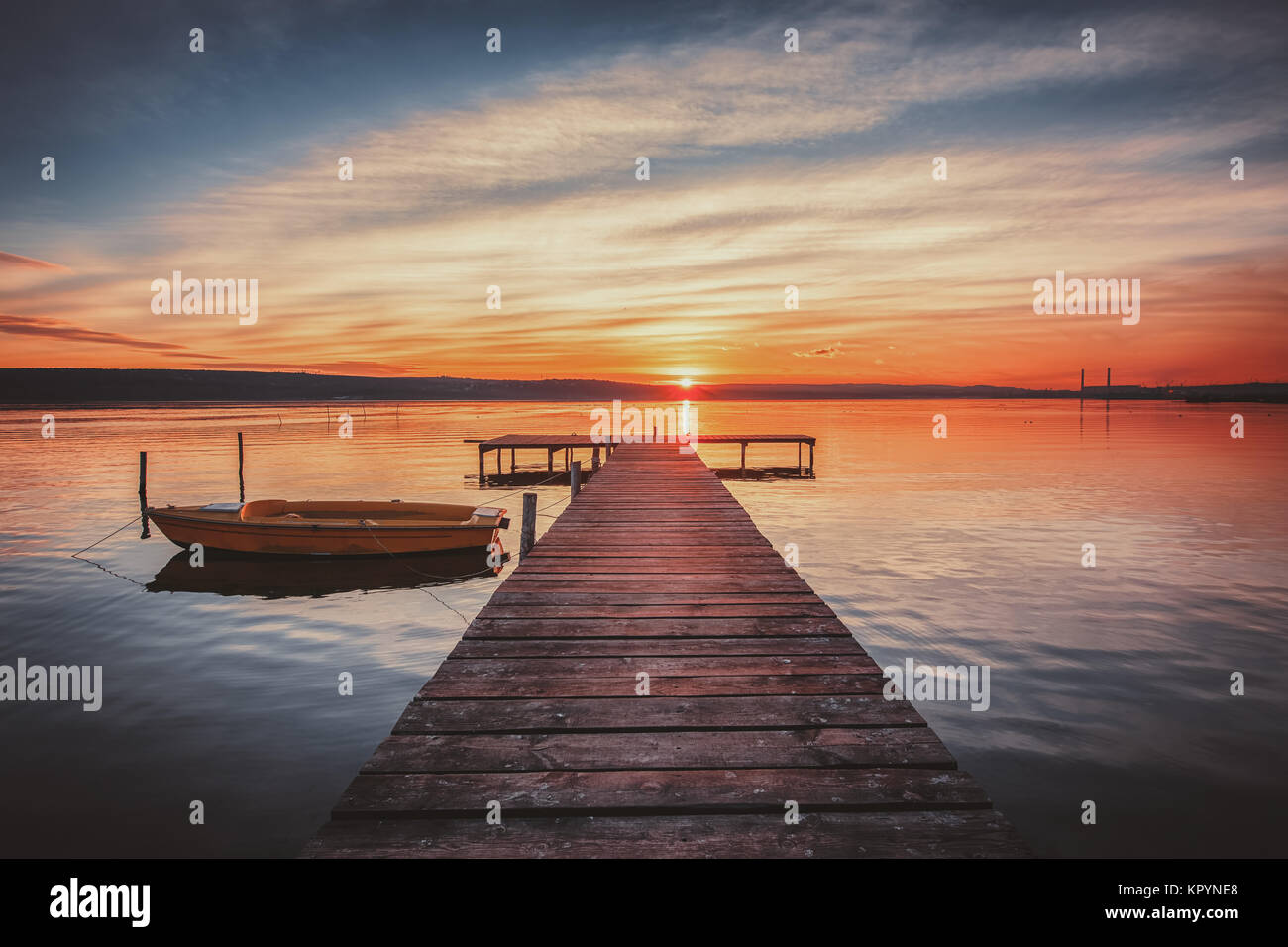 Small Dock and Boat at the lake, sunset shot Stock Photo - Alamy