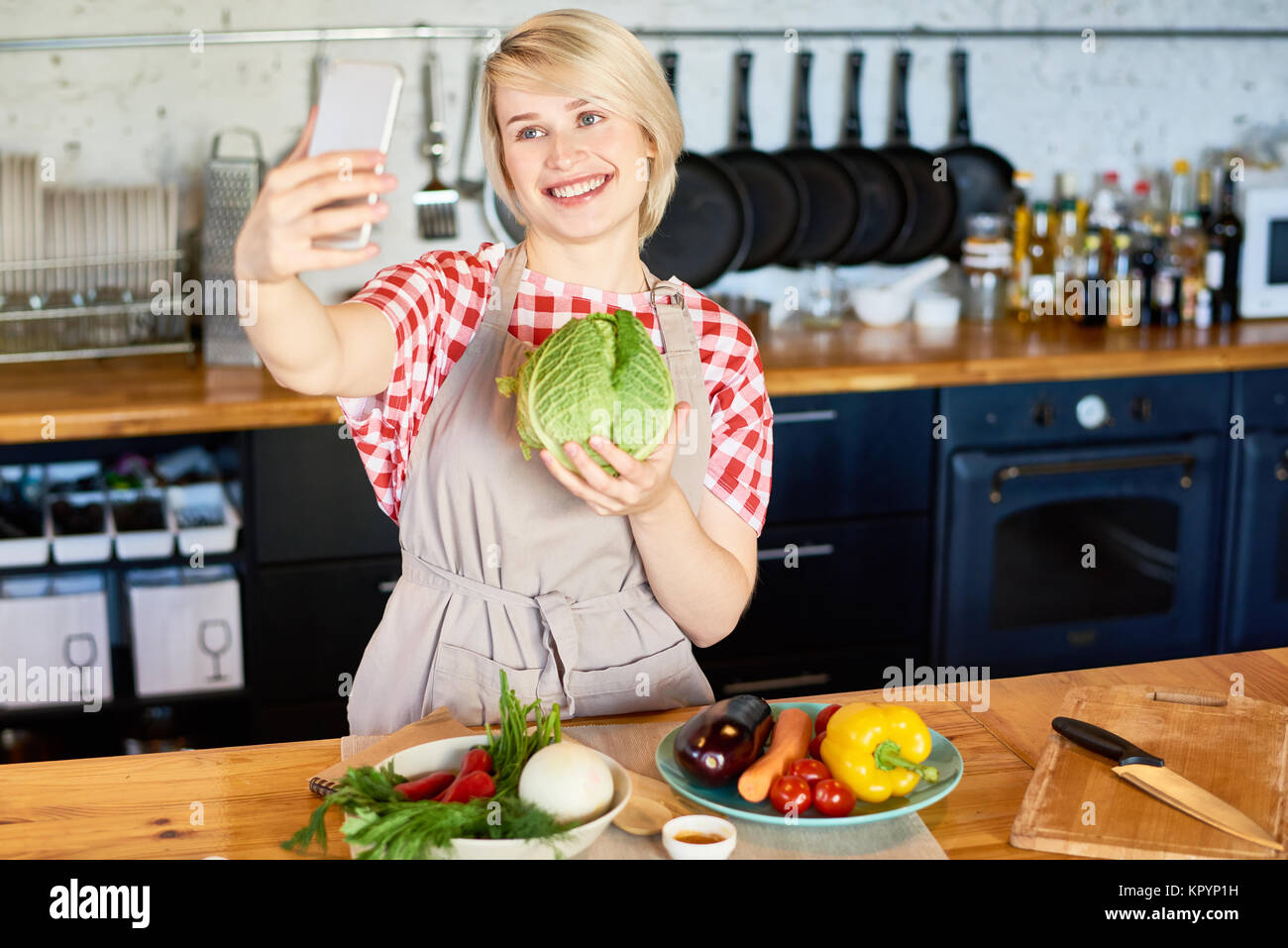 Young Woman Taking Selfie in Kitchen Stock Photo