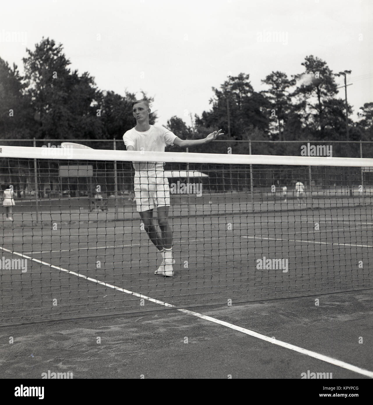 1960s, historical, outdoor clay court, a clean-cut young adult male tennis player by the net practising his volleying technique, USA. Stock Photo