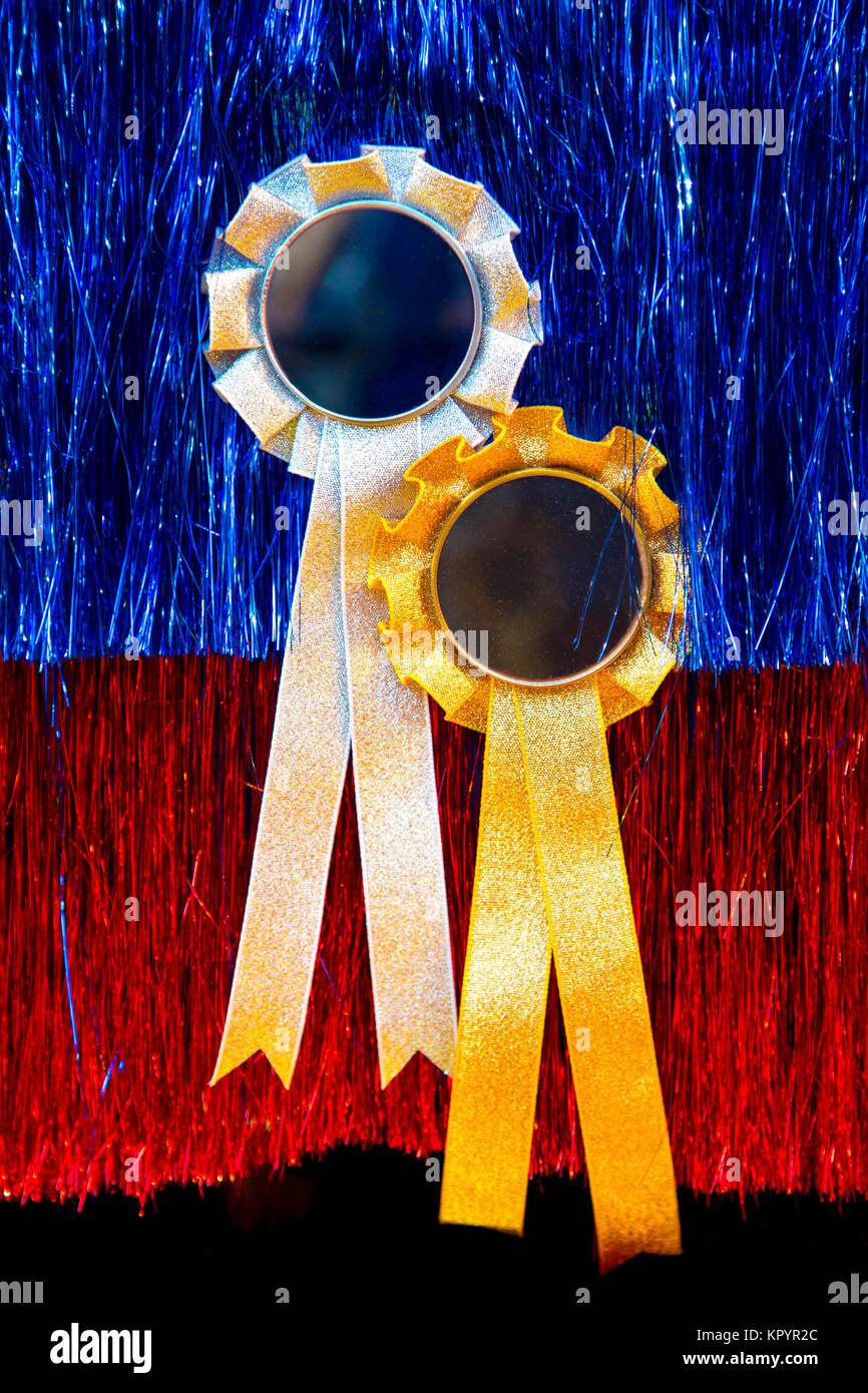 Award rosettes with ribbons against tinsel background Stock Photo