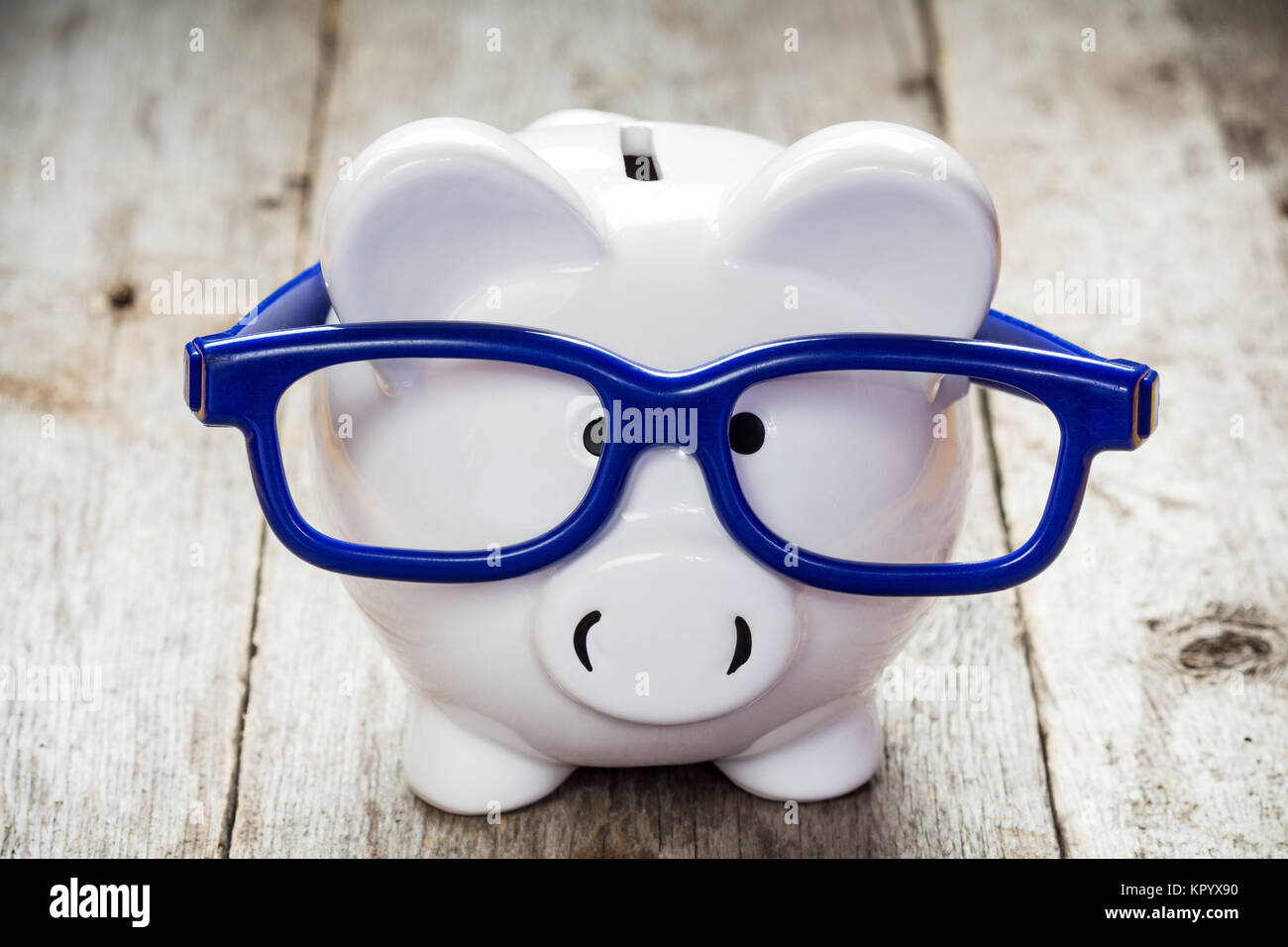 Piggy bank with blue glasses Stock Photo - Alamy