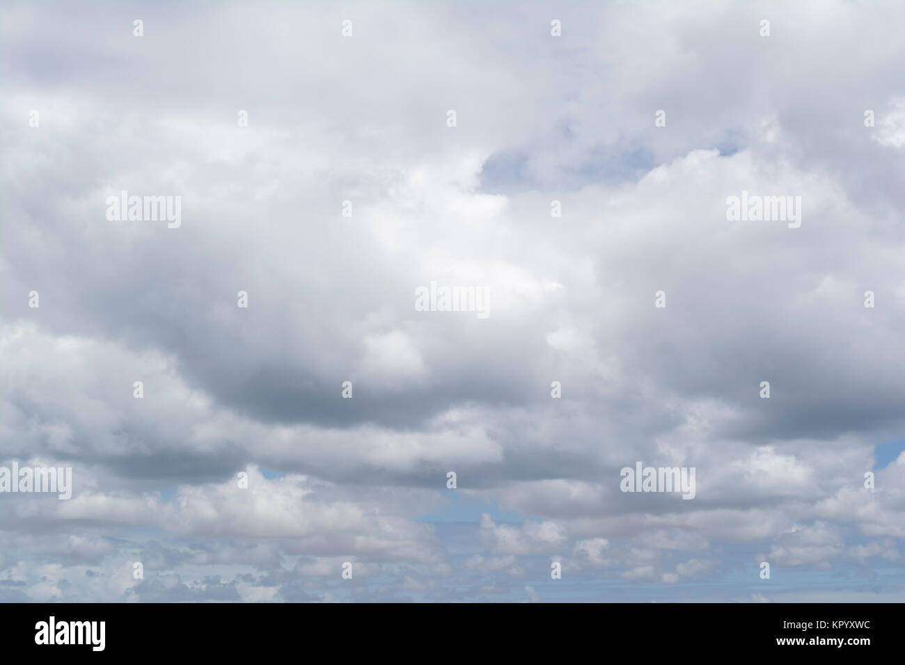 Fluffy soft white cloud formations showing just a small amount a pale