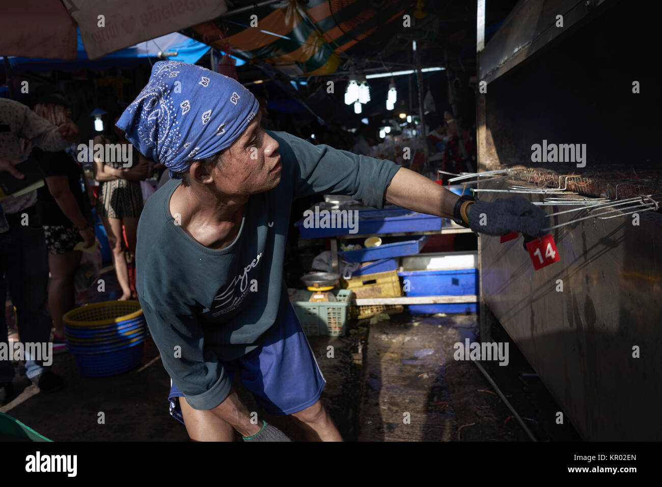 Man cooking. Close up of a BBQ chef cooking on an open range in a Thailand street market. Stock Photo