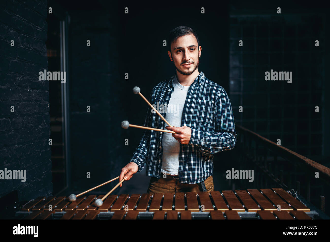 Young male xylophone player with sticks in hands, wooden sounds