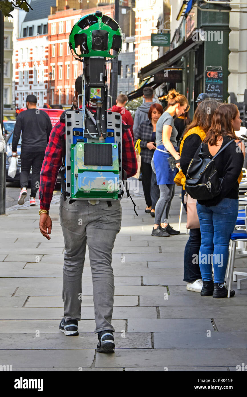 Man walking pavement London West End England UK with Google trekker camera back pack strapped to body used to make street view scenes on pegman map Stock Photo