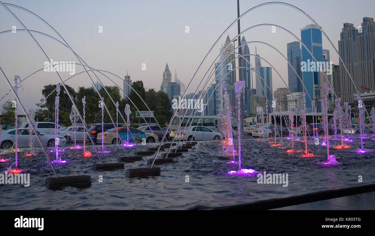 Many small splashing dancing fountains in summer Dubai park. Outdoor small fountains in order to