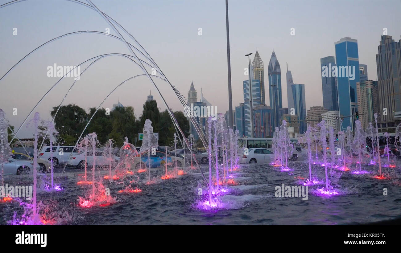 Many small splashing dancing fountains in summer Dubai park. Outdoor