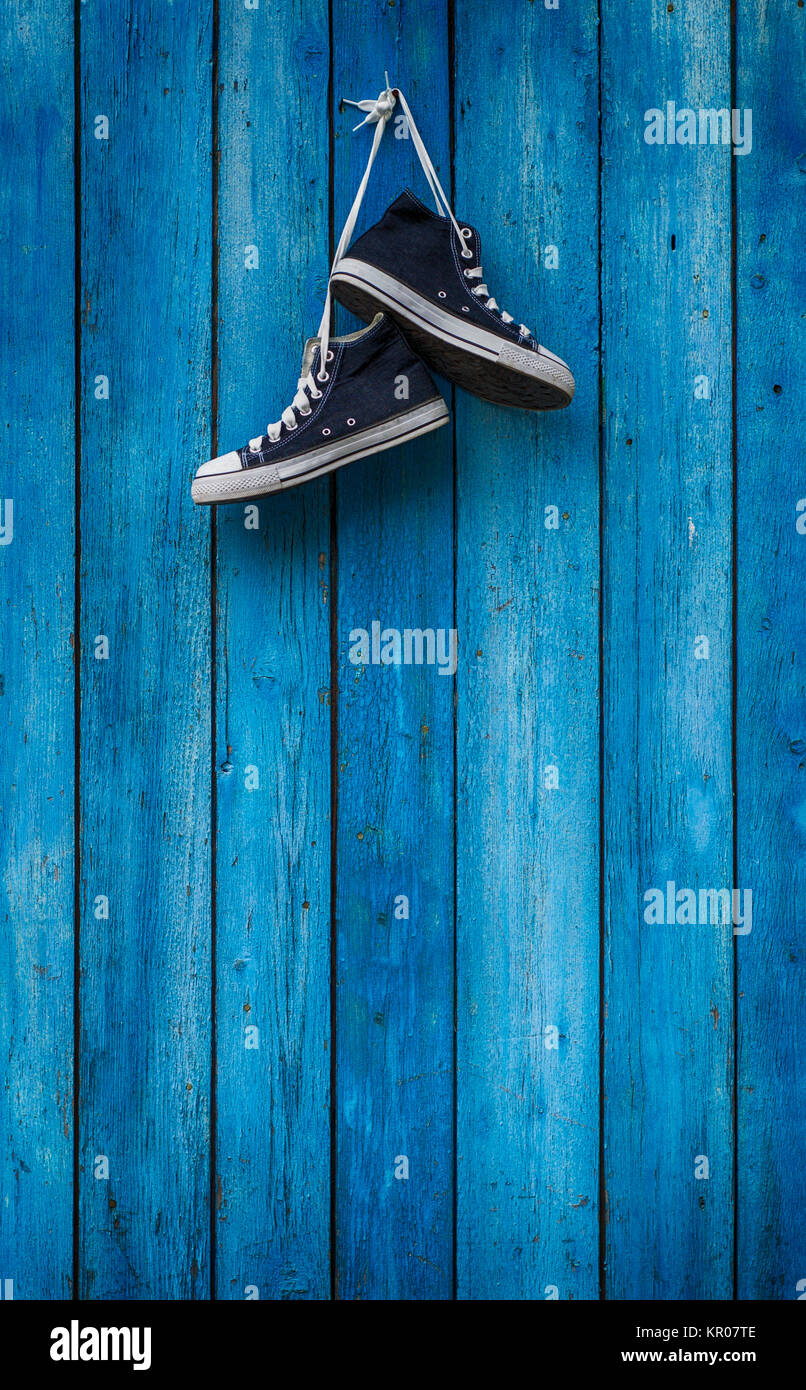 Pair blue sneakers on a wooden wall Stock Photo - Alamy