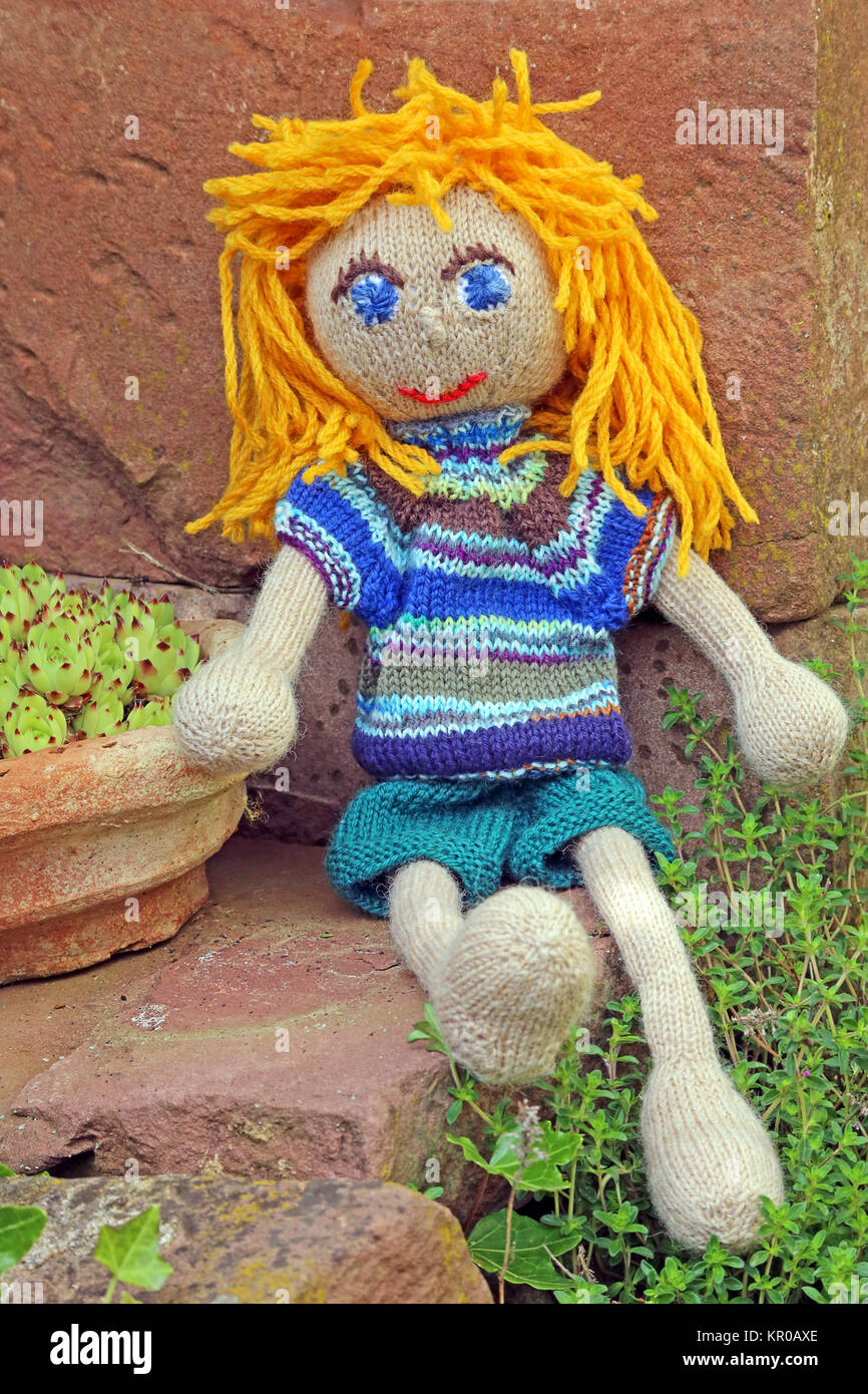 doll in the garden in front of red sandstone Stock Photo Alamy