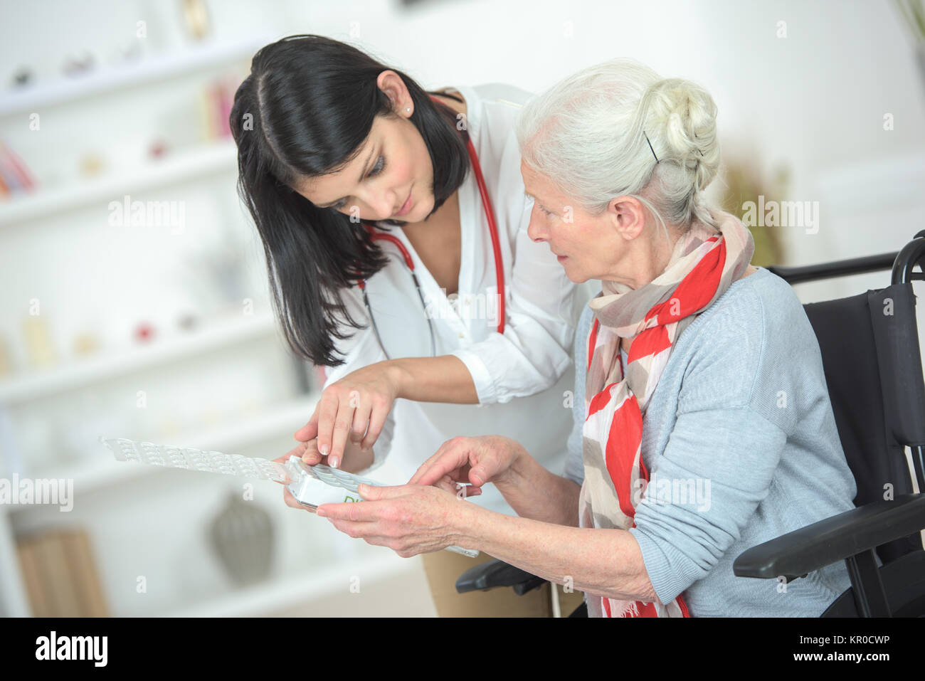 Talking old lady through her medication Stock Photo