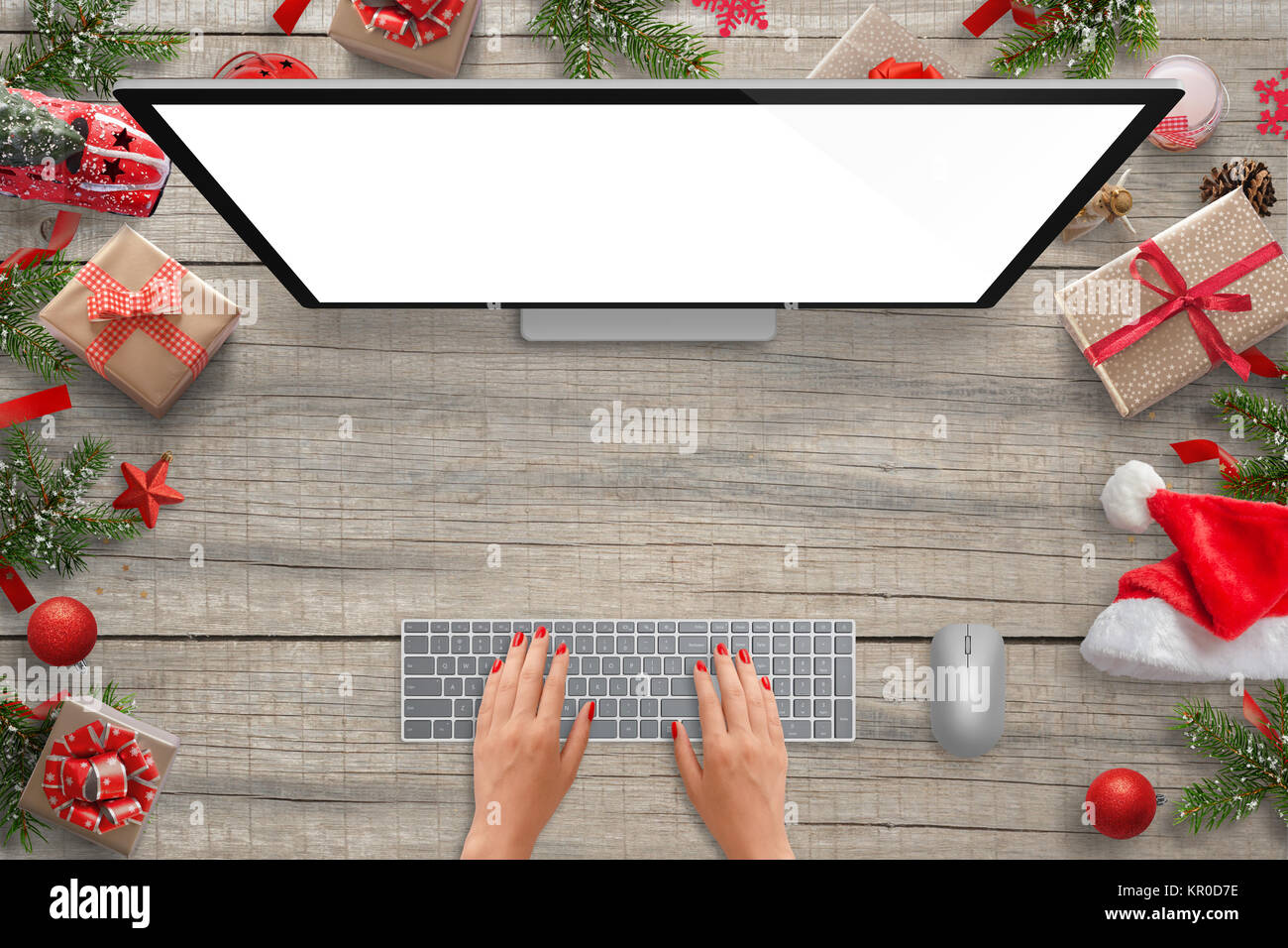 Work on computer with isolated screen for mockup presentation. Christmas scene with decorations. Woman typing on keyboard. Top view. Stock Photo