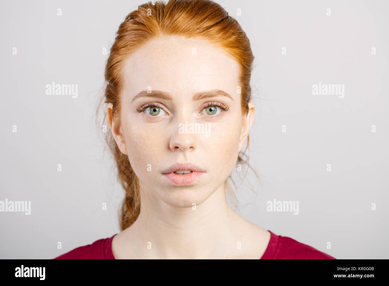 beautiful young redhead girl with clean fresh face and neutral emotions close up Stock Photo