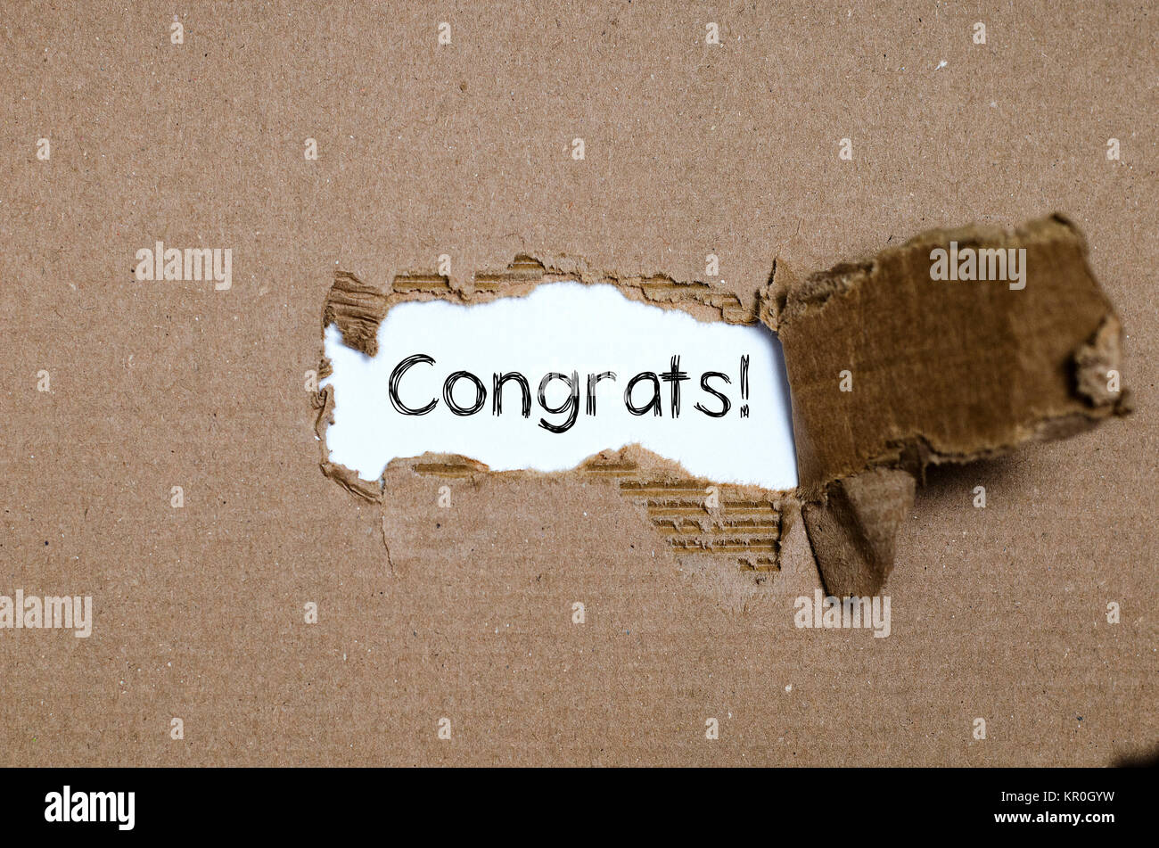 The word congrats appearing behind torn paper. Stock Photo