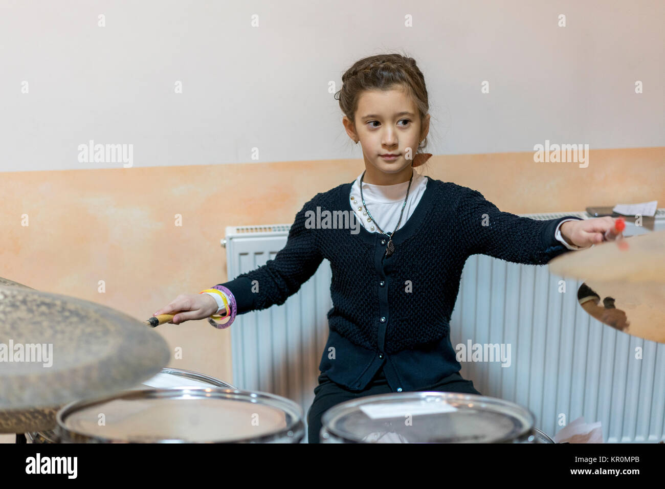 young caucasian teenage girl plays the drums Stock Photo